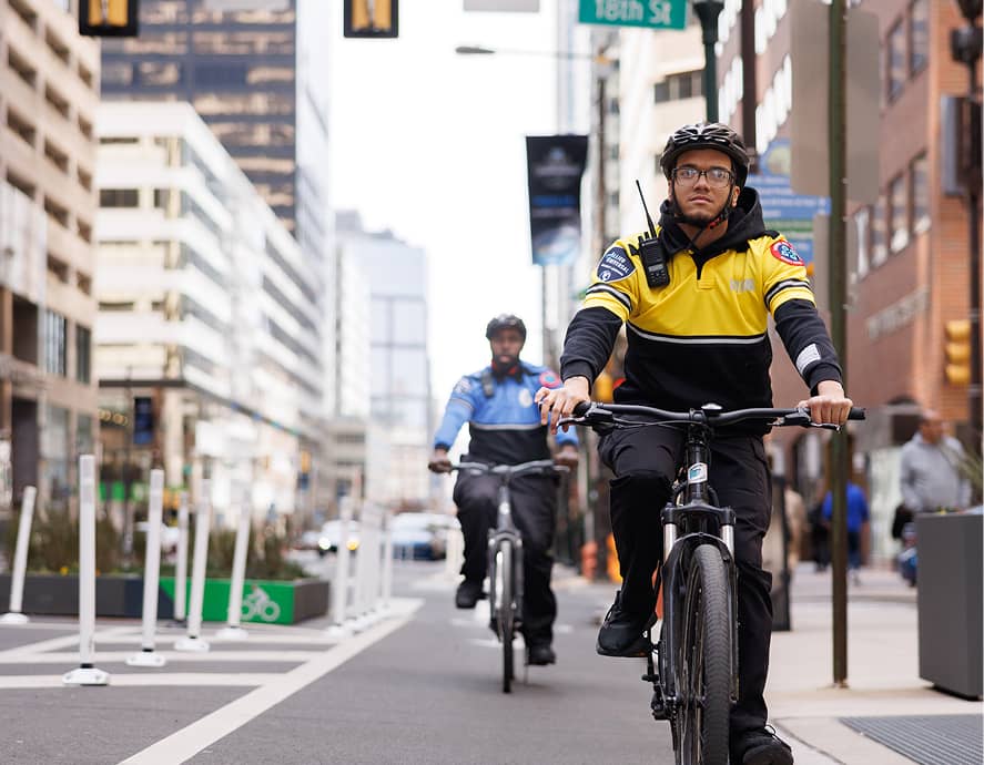 CCD public safety bike patrol officers, wearing yellow jackets, bike helmets and carrying a 2-way radio, riding on their bikes.