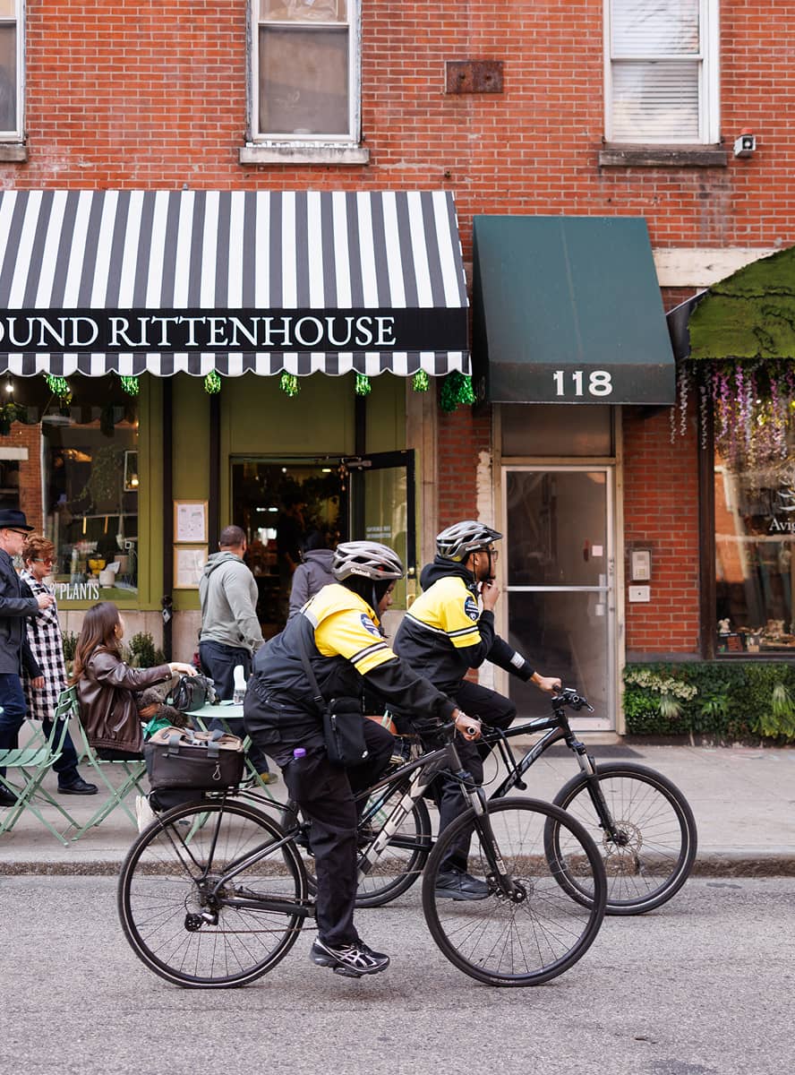 CCD public safety bike patrol officers, wearing yellow jackets, bike helmets and carrying a 2-way radio, riding on their bikes.