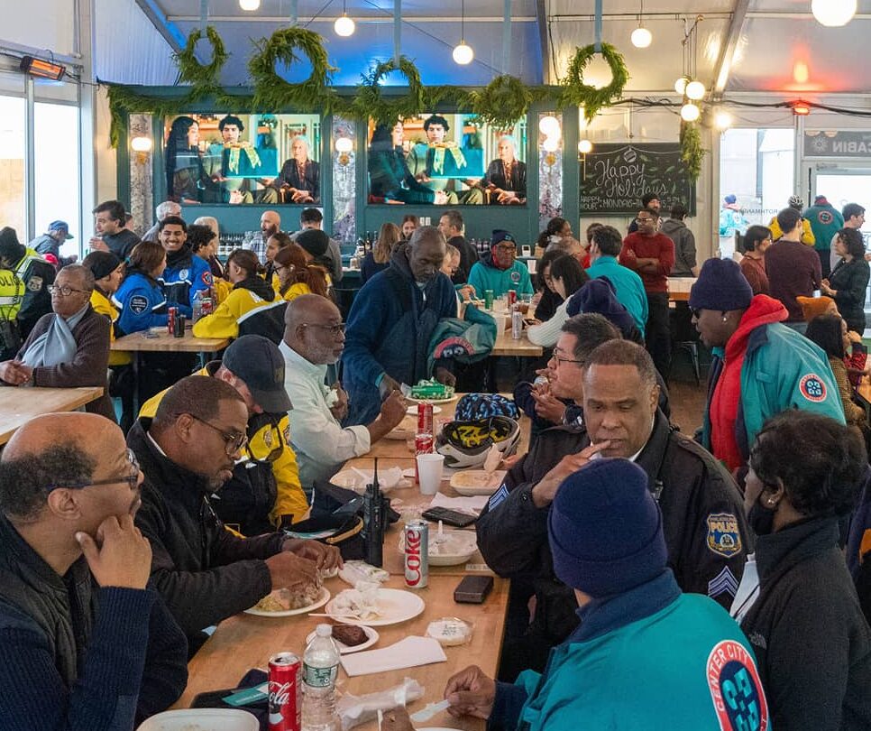 Center City District staff photo during a holiday event, which includes administrative staff, Community Service Representatives, maintenance staff, outreach workers, public safety bike patrol, park staff and Philadelphia Police Officers.