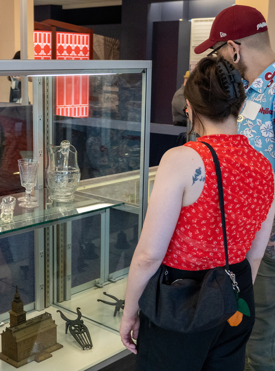 People viewing artifacts at the Revisit 1876 exhibit.