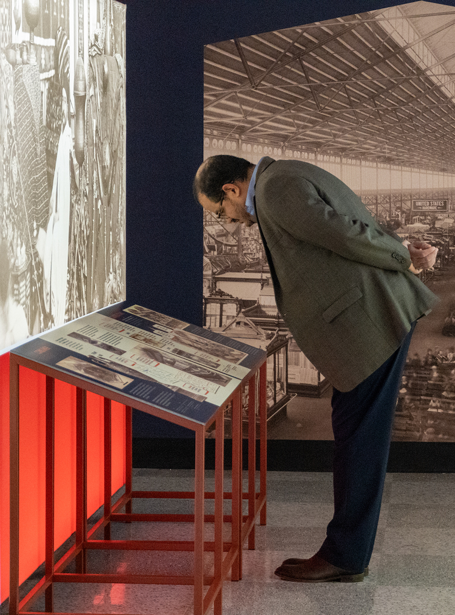 Person reading information panel at the Revisit 1876 exhibit.