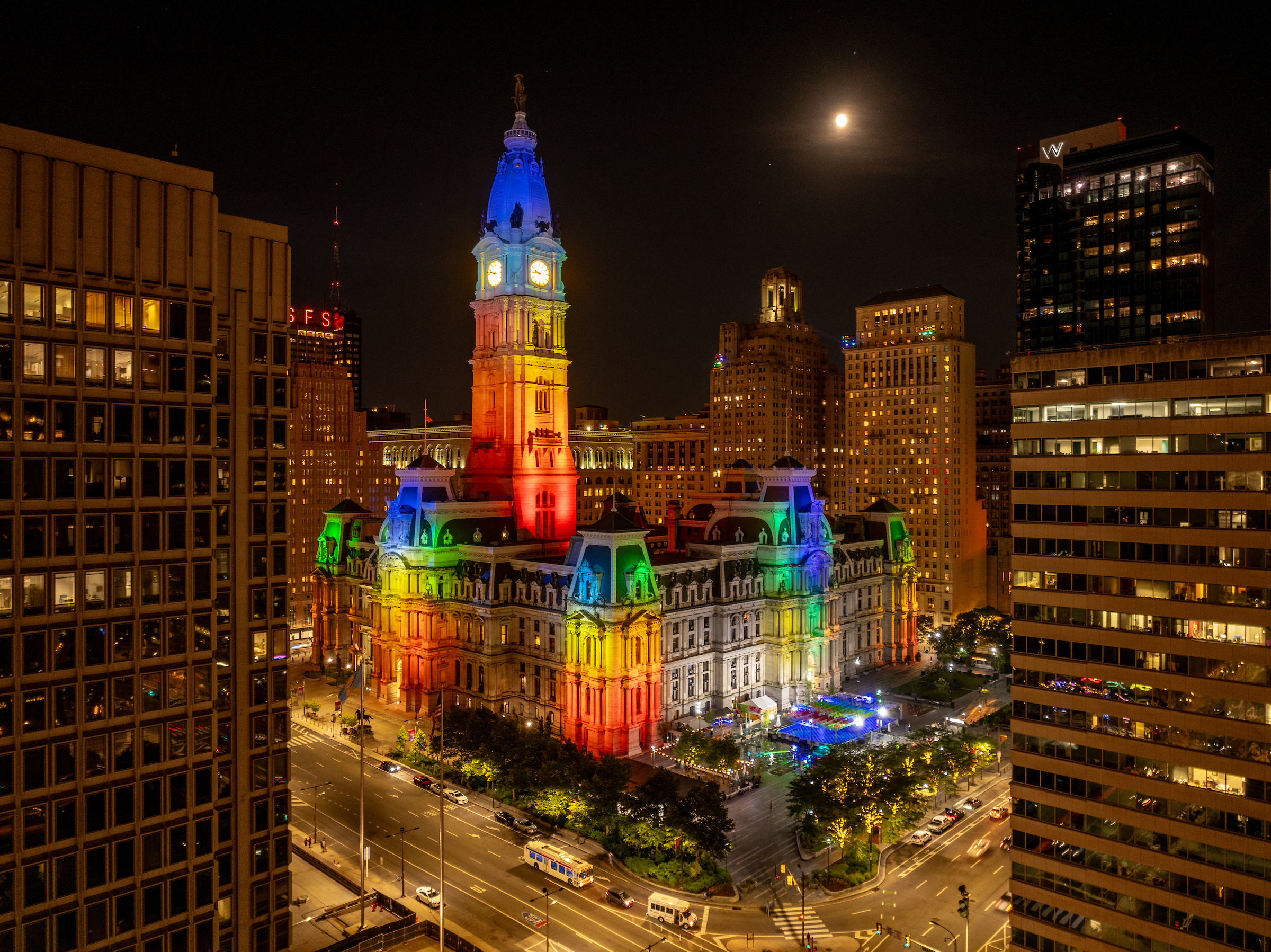 Philadelphia's City Hall lit with rainbow colors at night.
