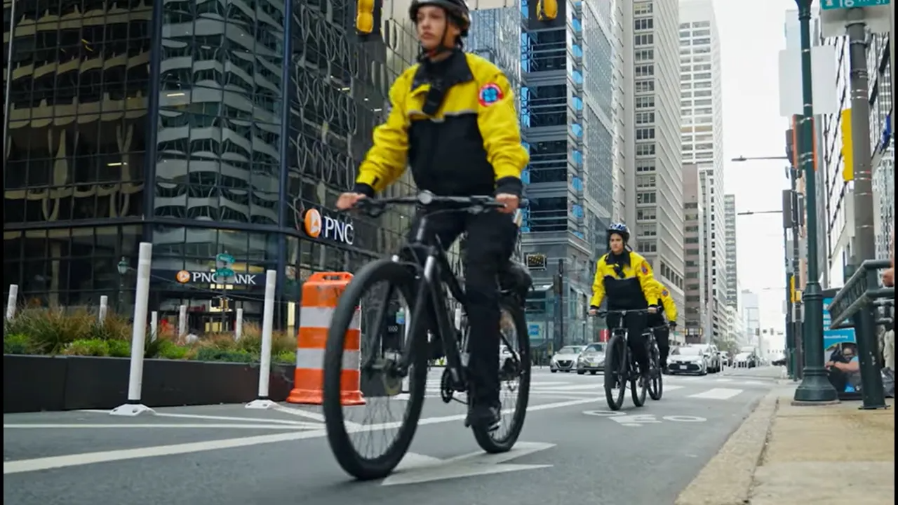 CCD public safety bike patrol officers, wearing yellow jackets, bike helmets and carrying a 2-way radio, riding on their bikes.