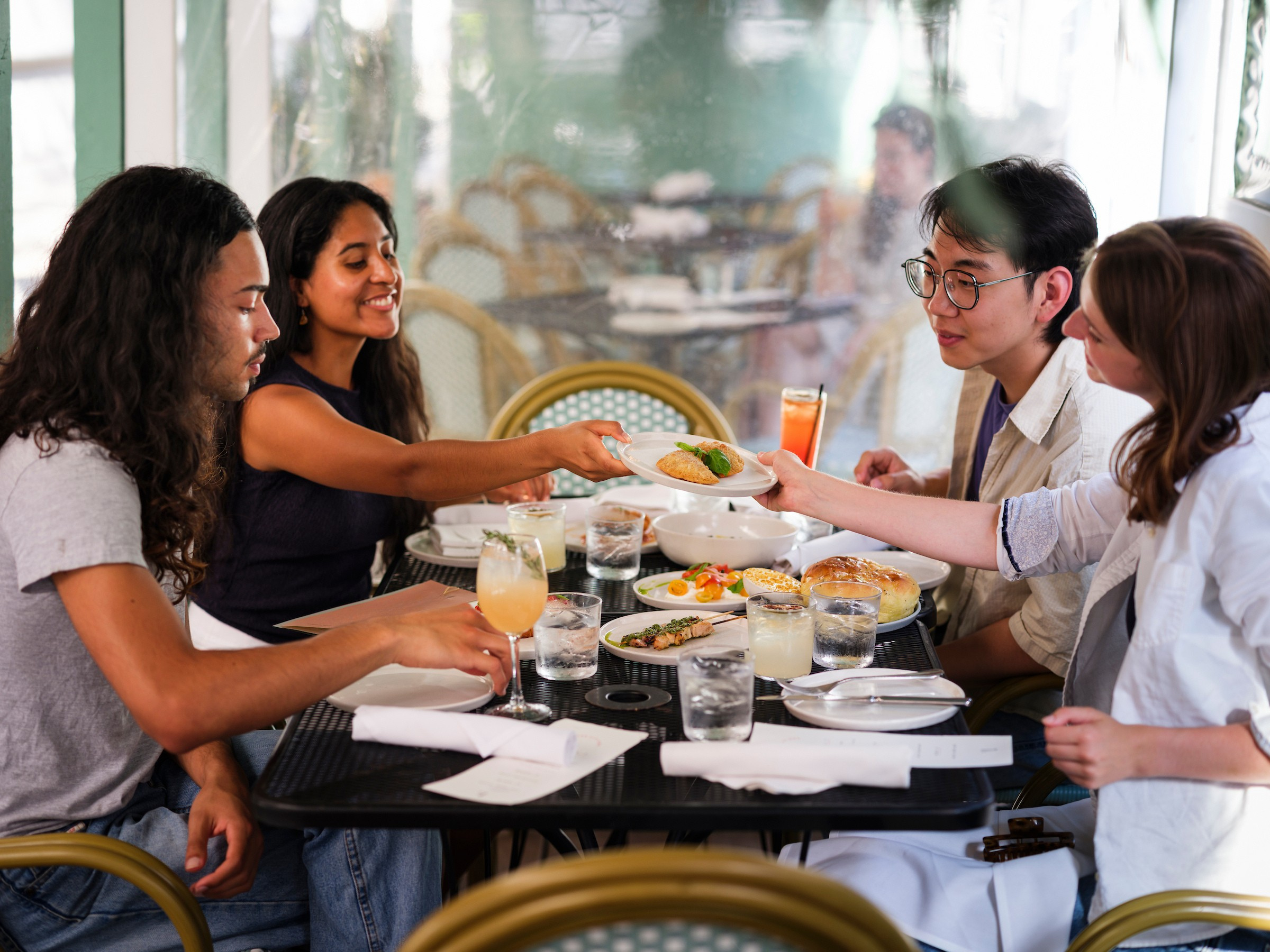 four people sitting at a table at a restaurant over lunch