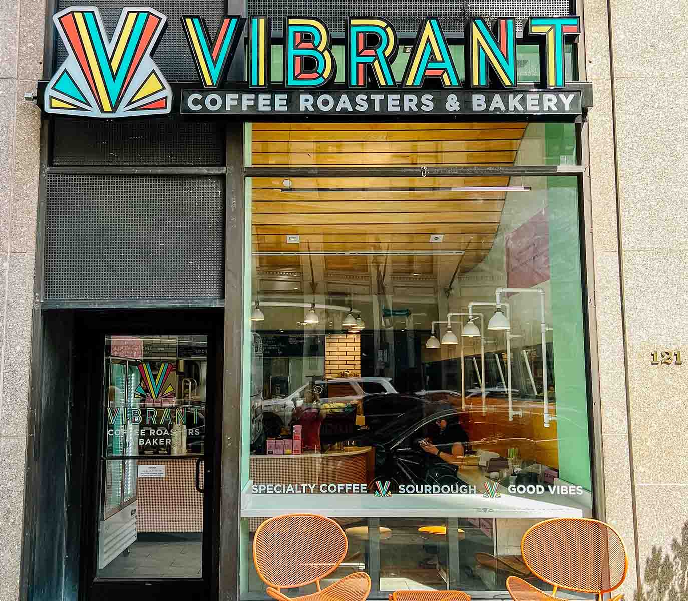 Vibrant coffee shop exterior with table and 2 chairs